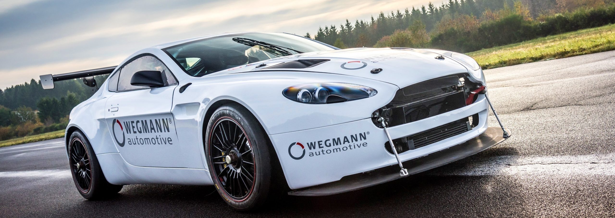 a white sports car with a broken front bumper